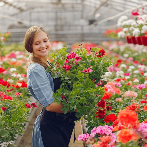 woman-black-apron-working-greenhouse-min